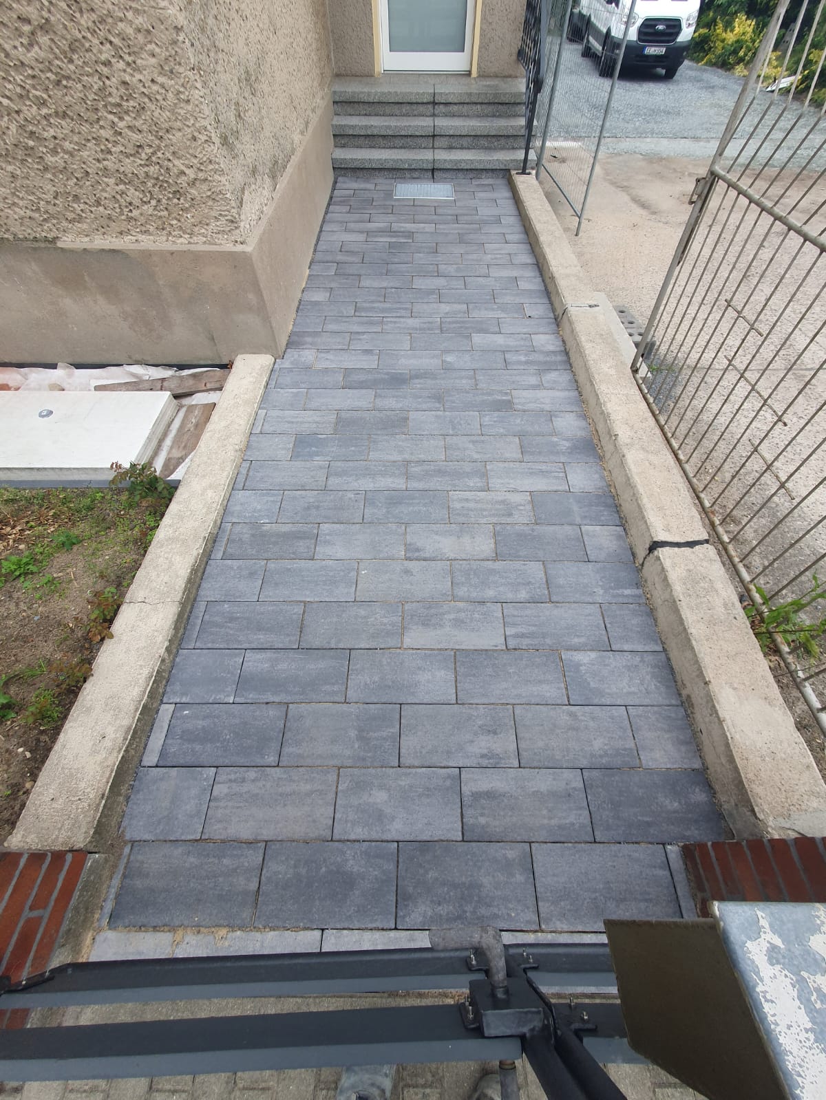 Pflasterarbeiten eines Eingangsbereiches mit großformatigem Rechteckpflaster, Farbe: anthrazit