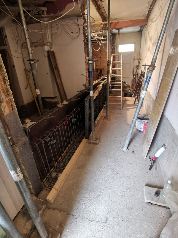 Gründungssicherung eines alten Fachwerkhauses mit schlechtem Unterboden über Punktfundamente und darüberliegendem Stahlbetonbalken als Lastverteilung